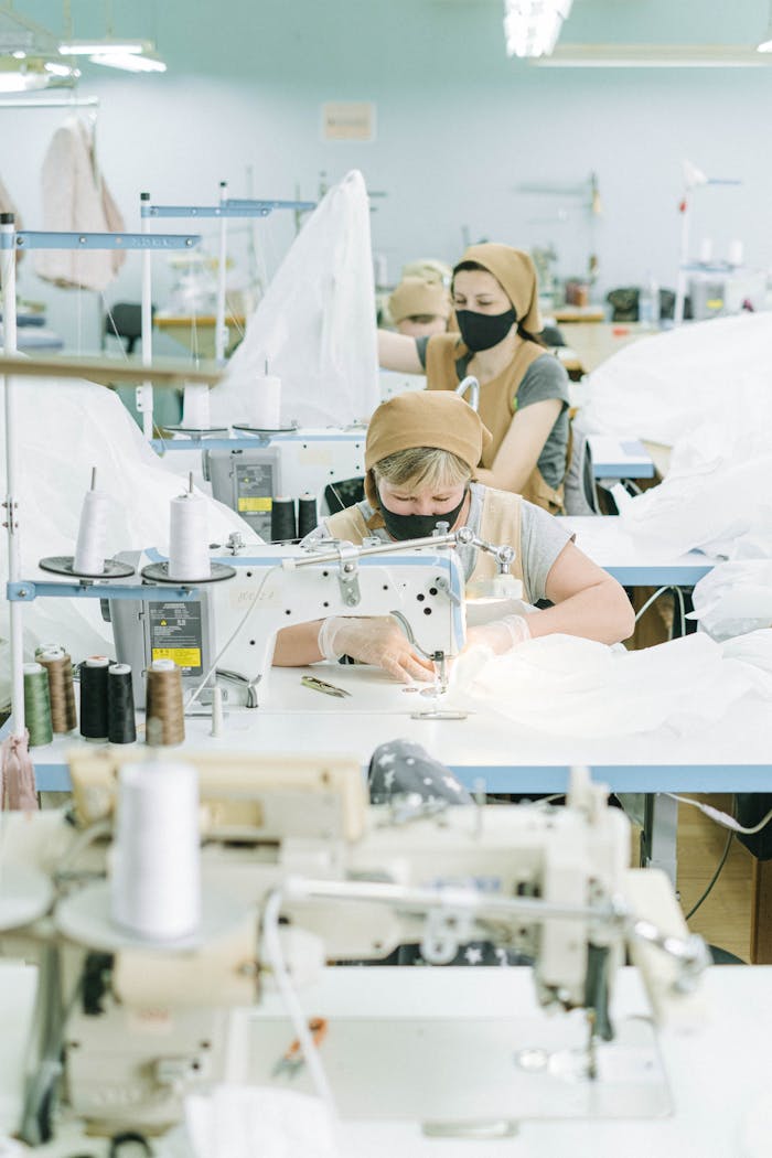 Women using sewing machines in a textile manufacturing workshop.